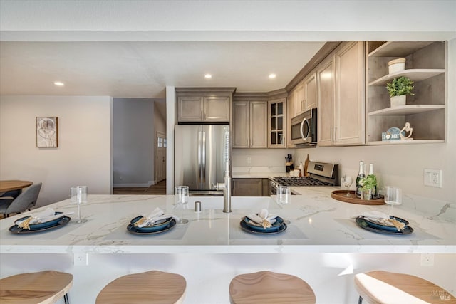 1779 Monarch Dr, Napa, CA 94558 - kitchen with light stone counters, appliances with stainless steel finishes, kitchen peninsula, and a breakfast bar area