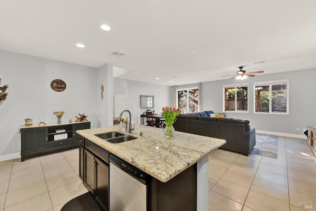 kitchen with dishwasher, light stone counters, light tile patterned flooring, and a sink