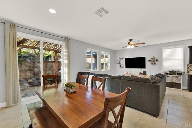 dining area featuring light tile patterned floors, visible vents, a wealth of natural light, and a ceiling fan