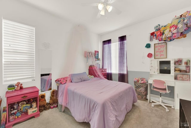 bedroom with light carpet and a ceiling fan