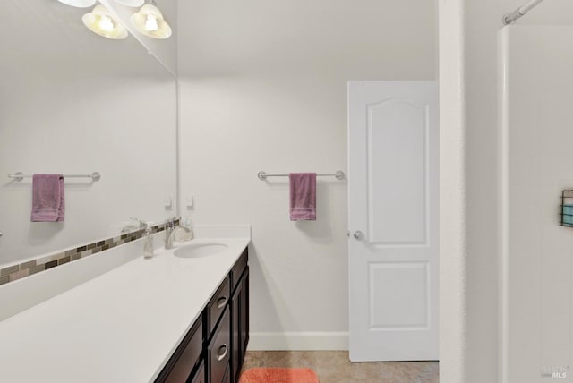 bathroom with vanity, baseboards, tile patterned flooring, and walk in shower