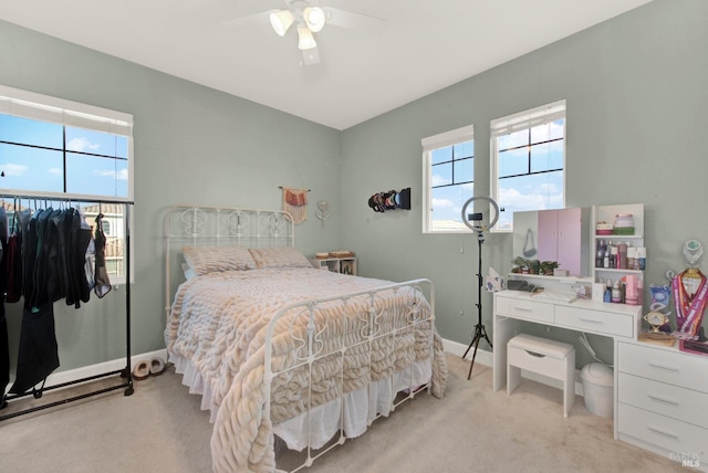 bedroom with light carpet, ceiling fan, and baseboards