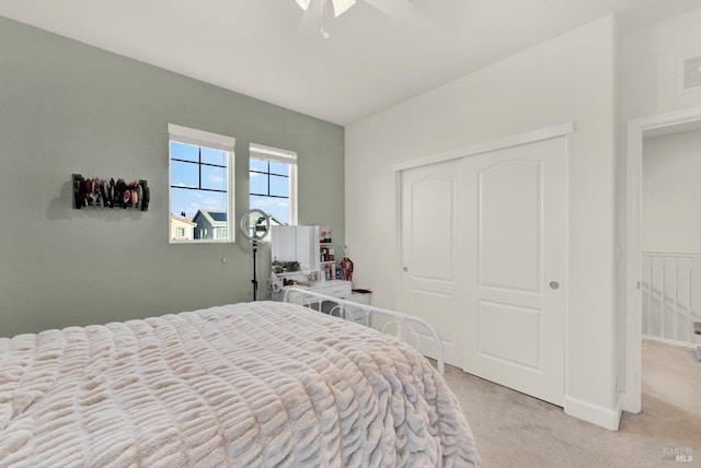 bedroom featuring a ceiling fan, visible vents, light colored carpet, and a closet