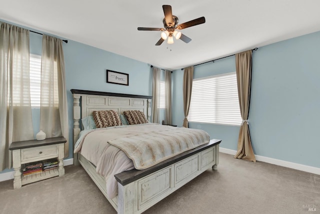 bedroom featuring multiple windows, baseboards, and light carpet