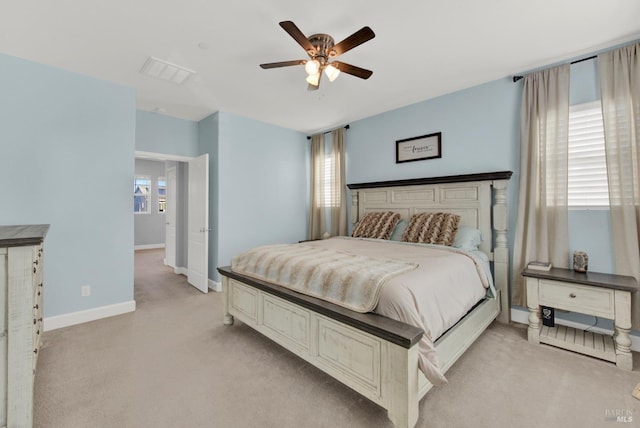 bedroom with multiple windows, visible vents, baseboards, and light carpet