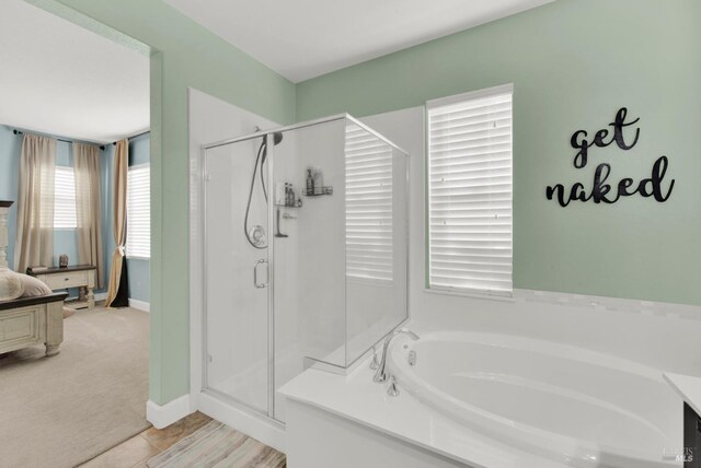 bathroom with connected bathroom, baseboards, a garden tub, and a shower stall