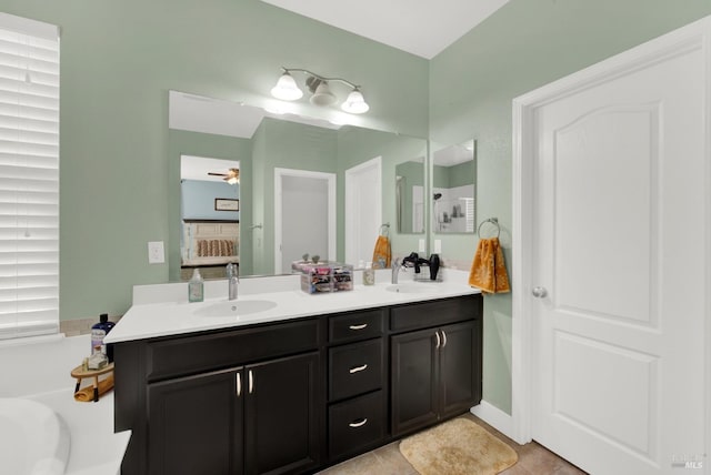 full bathroom featuring a ceiling fan, double vanity, a sink, tile patterned flooring, and a bath