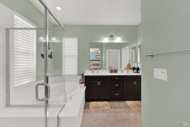 bathroom featuring a sink, a garden tub, a stall shower, and double vanity