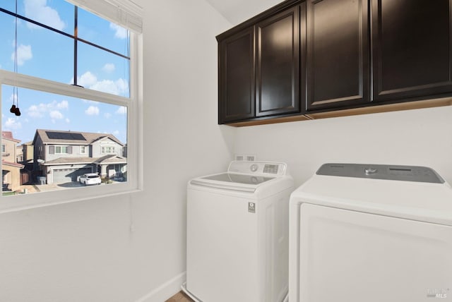 laundry area with washer and dryer, baseboards, and cabinet space