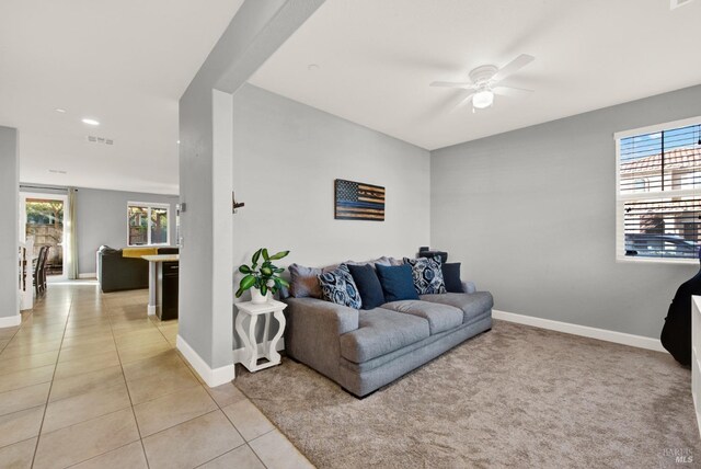 living room with light tile patterned flooring, baseboards, visible vents, and plenty of natural light