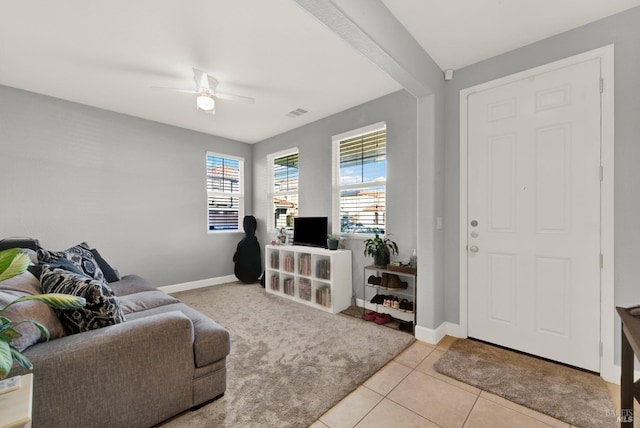 living area with visible vents, light tile patterned flooring, a ceiling fan, and baseboards