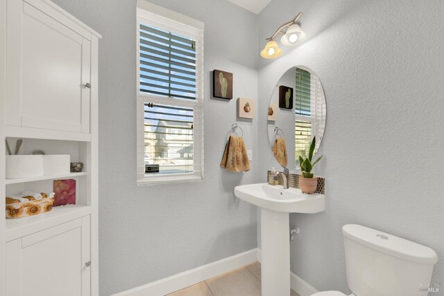 bathroom featuring tile patterned floors, baseboards, and toilet