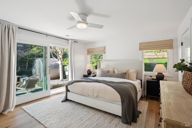 bedroom with ceiling fan, access to exterior, and light hardwood / wood-style flooring