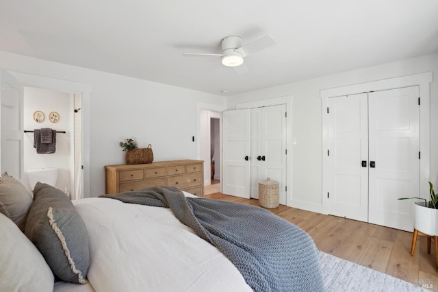 bedroom with multiple closets, connected bathroom, ceiling fan, and light hardwood / wood-style floors