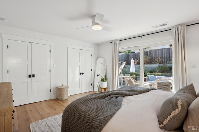 bedroom featuring multiple closets, access to outside, ceiling fan, and light hardwood / wood-style floors