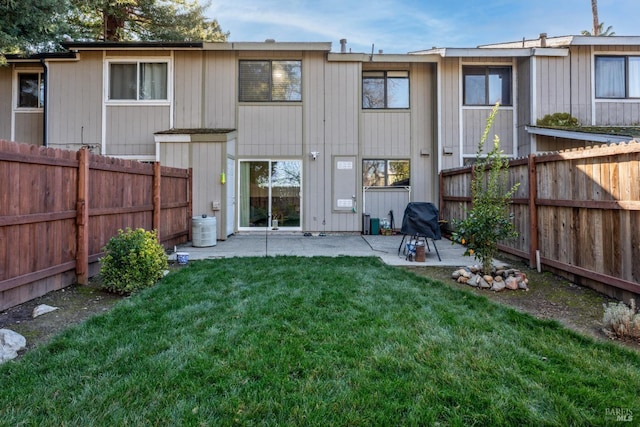 rear view of house featuring a yard and a patio area