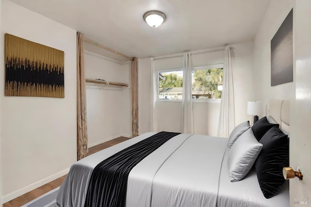 bedroom featuring baseboards and wood finished floors