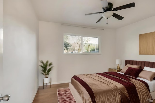 bedroom featuring light wood-style floors, baseboards, and a ceiling fan