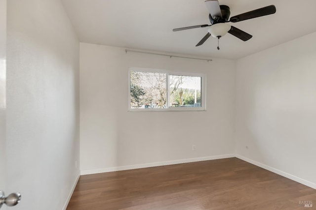 empty room with wood finished floors, a ceiling fan, and baseboards