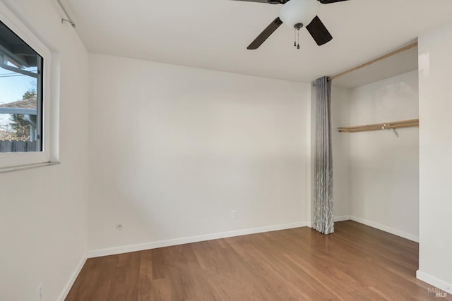 unfurnished bedroom with a closet, wood finished floors, and baseboards