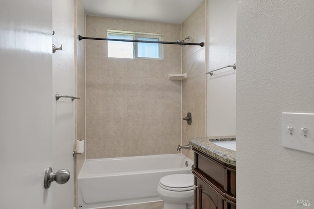 bathroom featuring a textured wall, shower / bathing tub combination, vanity, and toilet