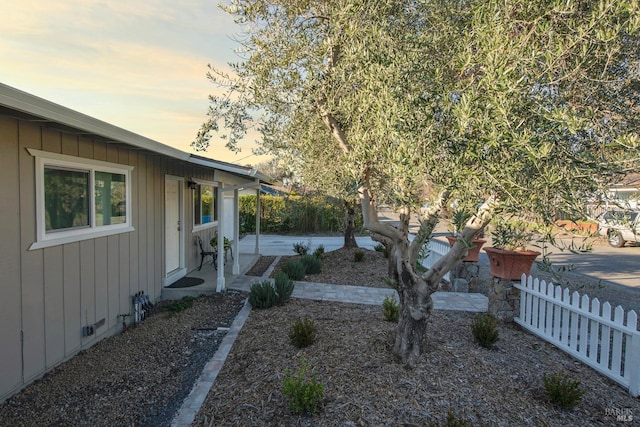 yard at dusk with a patio area and fence