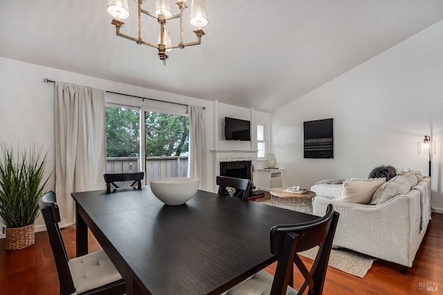 dining room featuring dark hardwood / wood-style flooring, vaulted ceiling, and an inviting chandelier