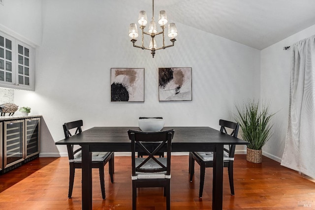 dining space featuring bar, lofted ceiling, hardwood / wood-style floors, and wine cooler