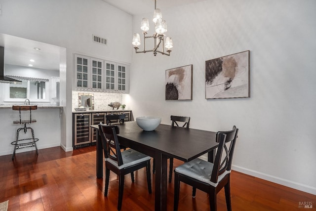 dining area featuring wine cooler, dark hardwood / wood-style floors, and bar