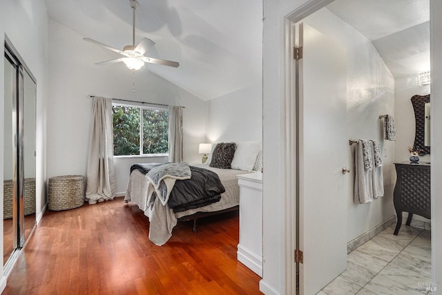 bedroom with vaulted ceiling, ceiling fan, and light wood-type flooring