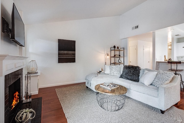 living room featuring dark hardwood / wood-style flooring and vaulted ceiling