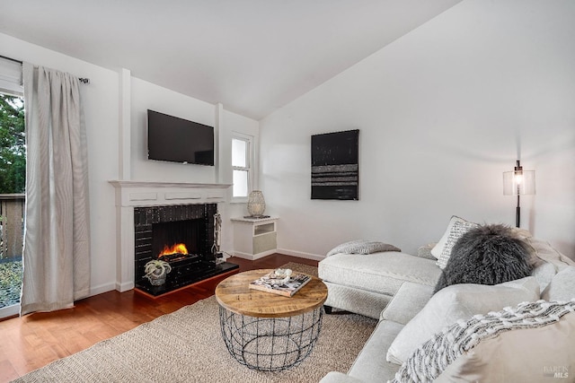 living room featuring a fireplace, vaulted ceiling, and hardwood / wood-style floors