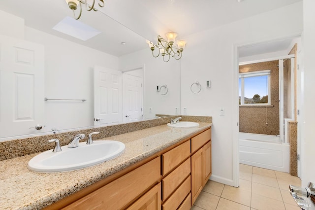 bathroom with tile patterned floors, a bathing tub, vanity, and a notable chandelier