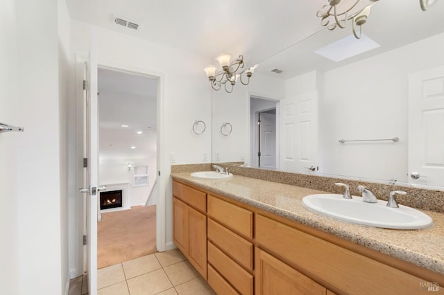 bathroom featuring tile patterned flooring, vanity, and an inviting chandelier