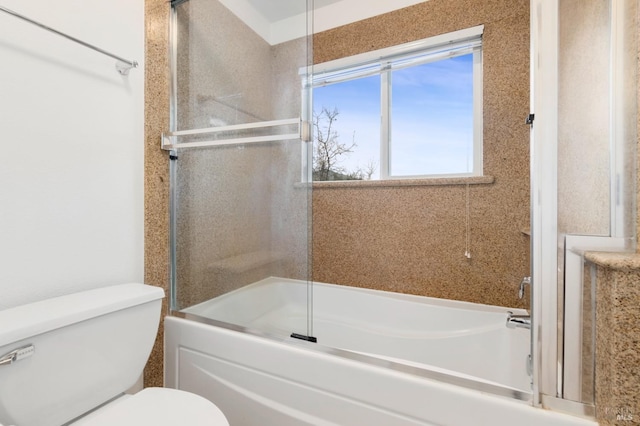 bathroom featuring toilet and combined bath / shower with glass door