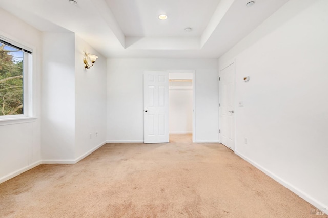 carpeted spare room with a tray ceiling