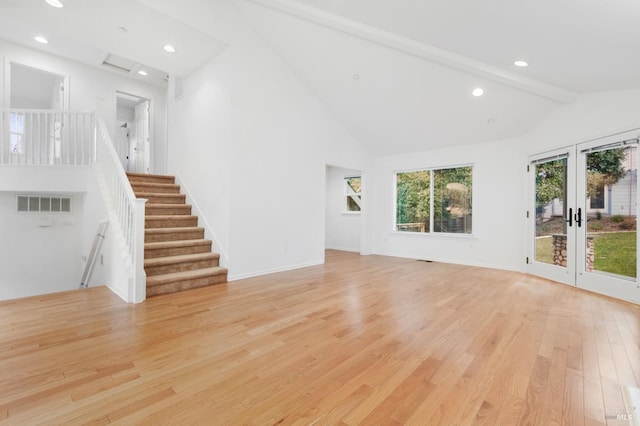 unfurnished living room with light hardwood / wood-style flooring, high vaulted ceiling, french doors, and beamed ceiling