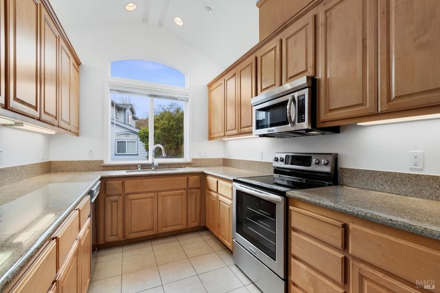 kitchen featuring sink, light tile patterned flooring, vaulted ceiling with beams, and appliances with stainless steel finishes