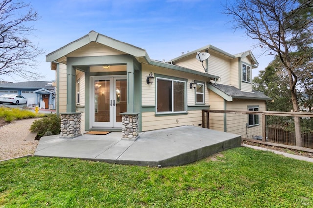 rear view of house with french doors, a yard, and a patio