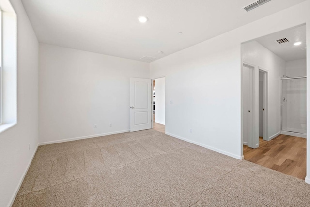 carpeted empty room with recessed lighting, visible vents, and baseboards