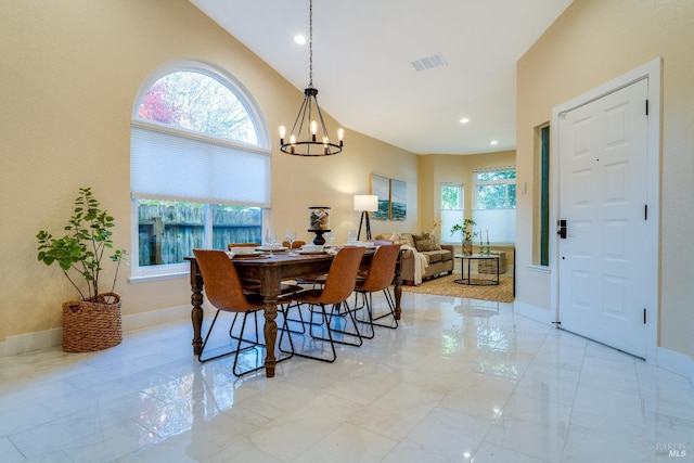 dining space featuring vaulted ceiling and an inviting chandelier