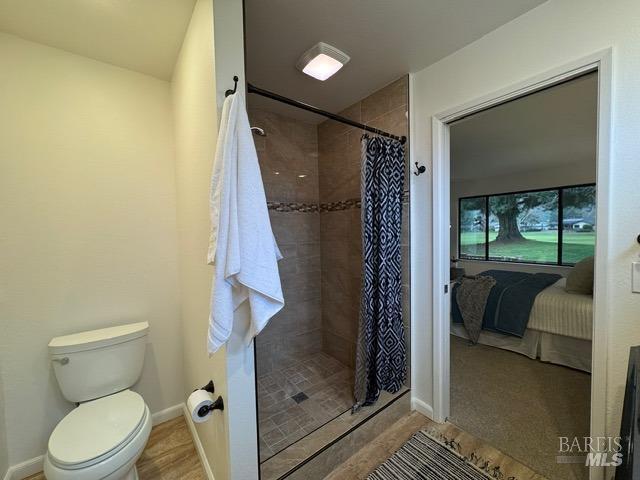 bathroom with walk in shower and toilet