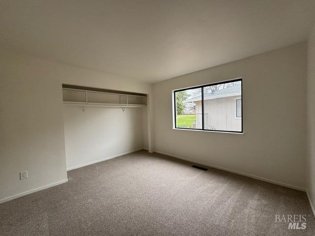 unfurnished bedroom with carpet floors and a closet