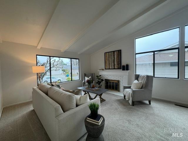 living room featuring a brick fireplace, lofted ceiling with beams, and carpet flooring