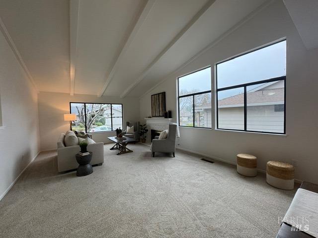 sitting room featuring high vaulted ceiling, carpet flooring, and beam ceiling