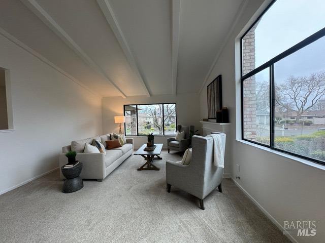 living room with light colored carpet and lofted ceiling with beams