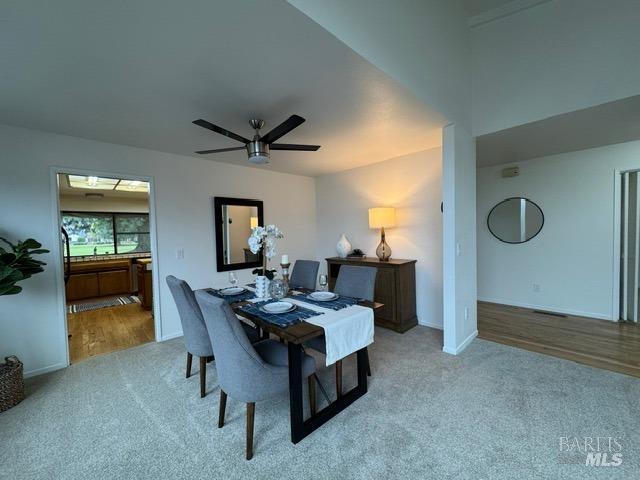 carpeted dining room featuring ceiling fan