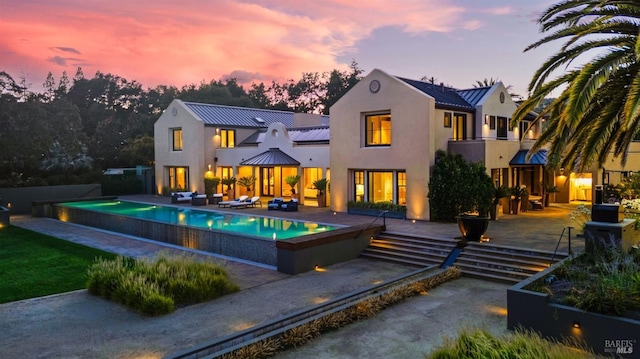 back house at dusk with a patio