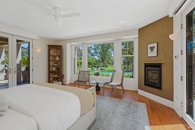 bedroom with french doors, ceiling fan, access to exterior, and hardwood / wood-style floors