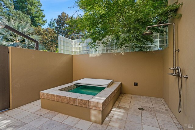 view of patio with an in ground hot tub